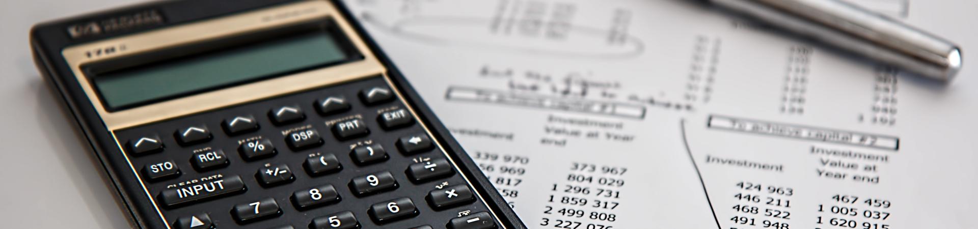 calculator with financial paper and pen
