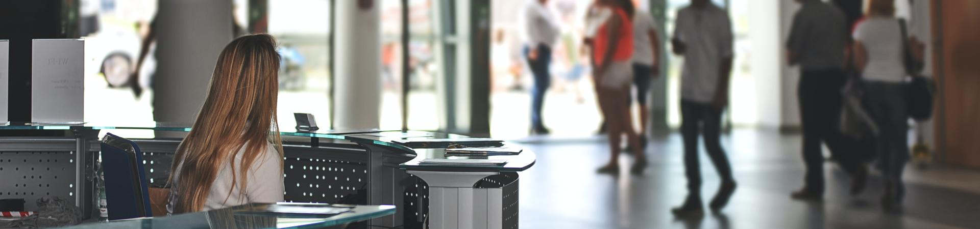 Customer service representative sitting at front desk