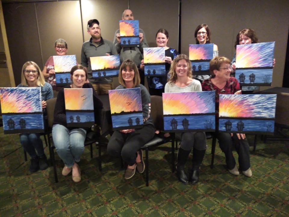 group of men and women with finished paintings